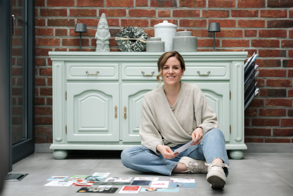 Corinna auf dem Boden mit Flyer am Arbeitsplatz